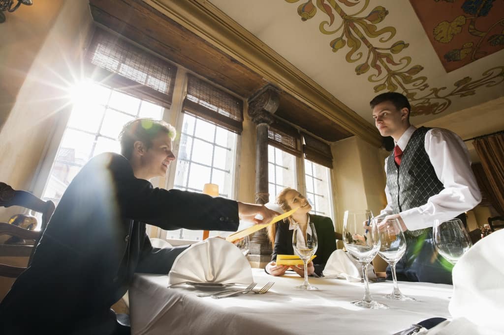 Smiling business couple ordering food at restaurant table