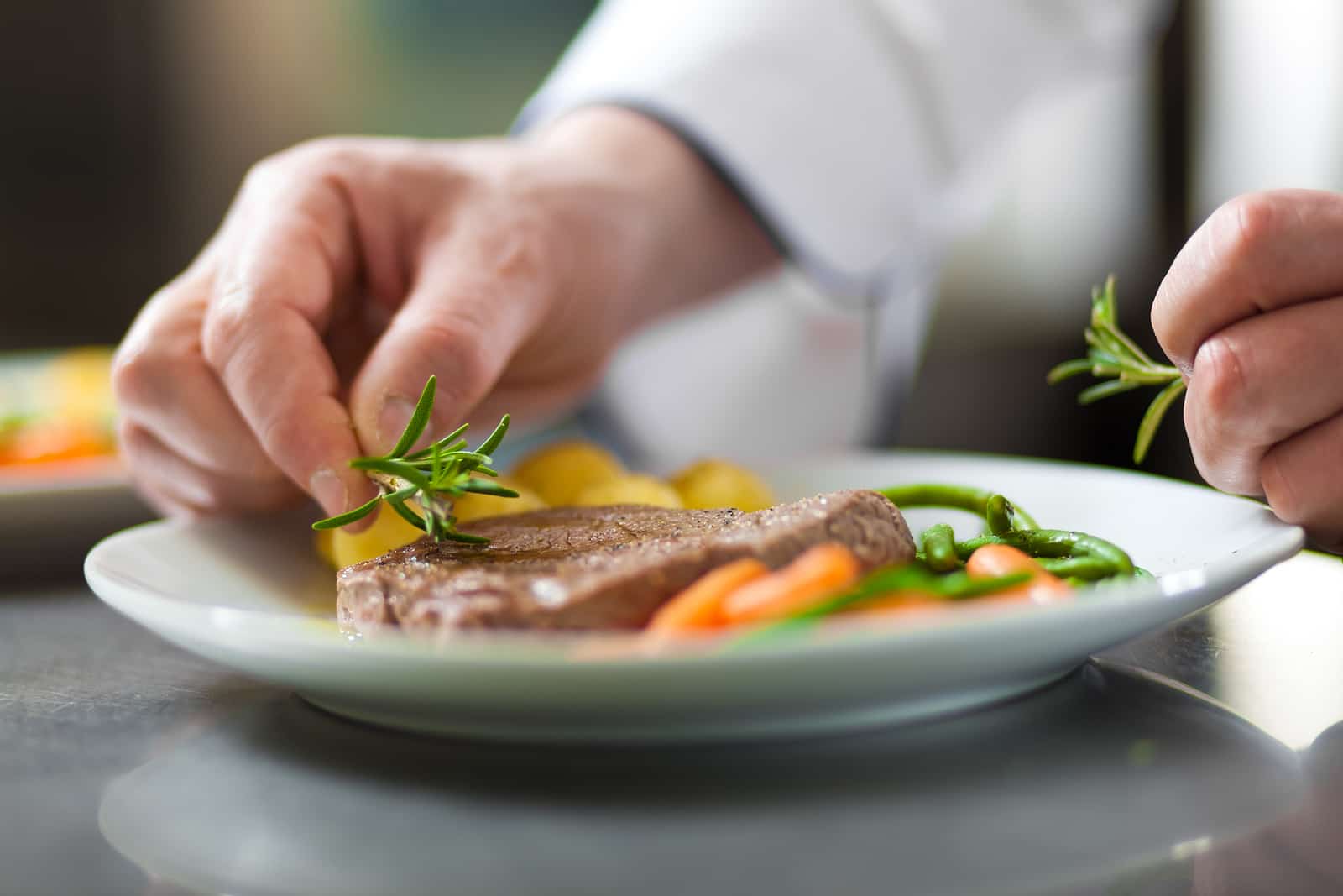 Chef decorating a dish in restaurant kitchen