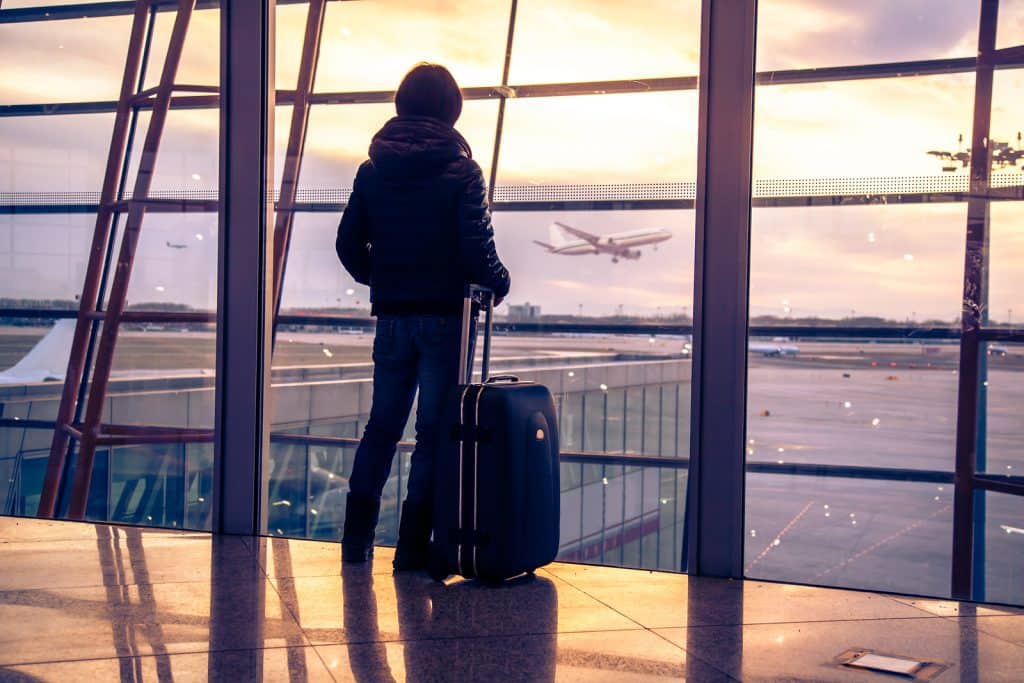 Person standing in airport after missed flight where bad service reflected on poor managers.