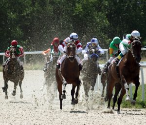 Jockeys riding horses hard - like a taskmaster manager does with his employees