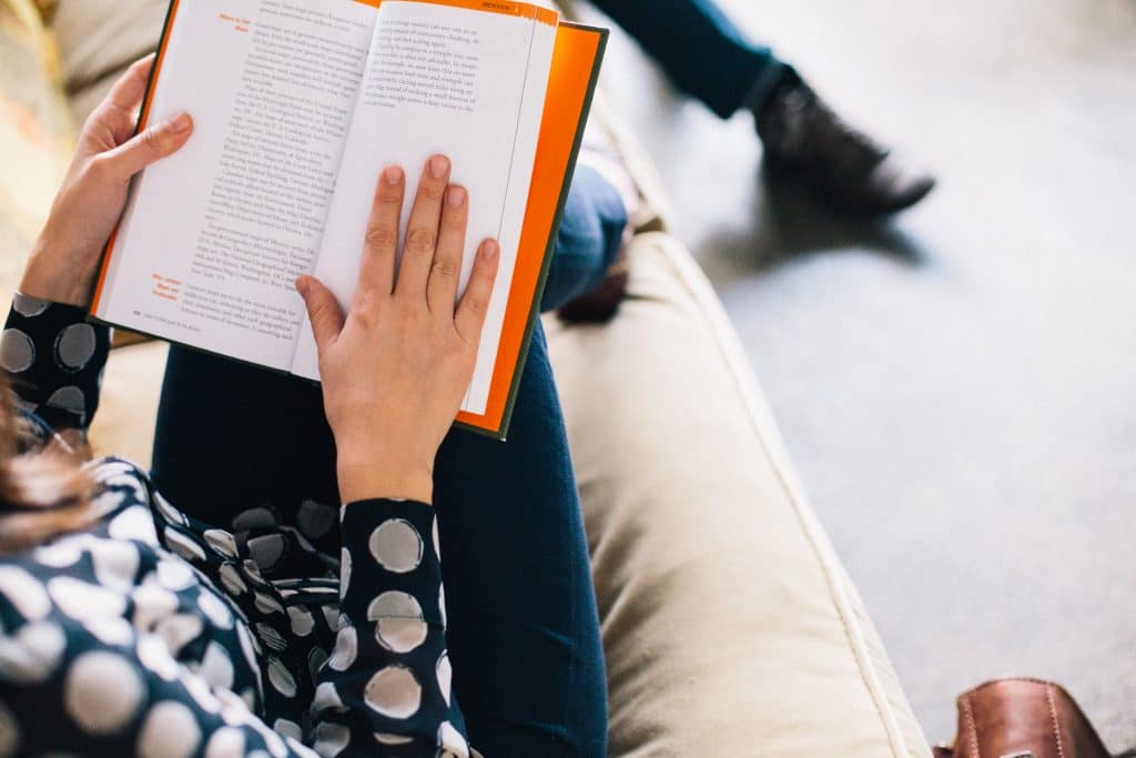 Woman reading book to learn effective leadership
