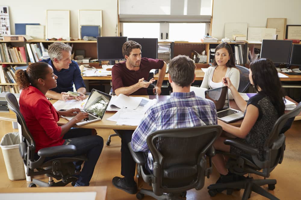 Group of workers in office using participative management.