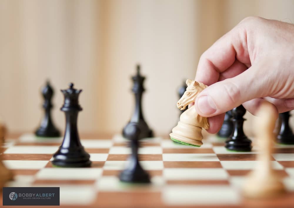 Person playing chess and exemplifying how successful people make better decisions .